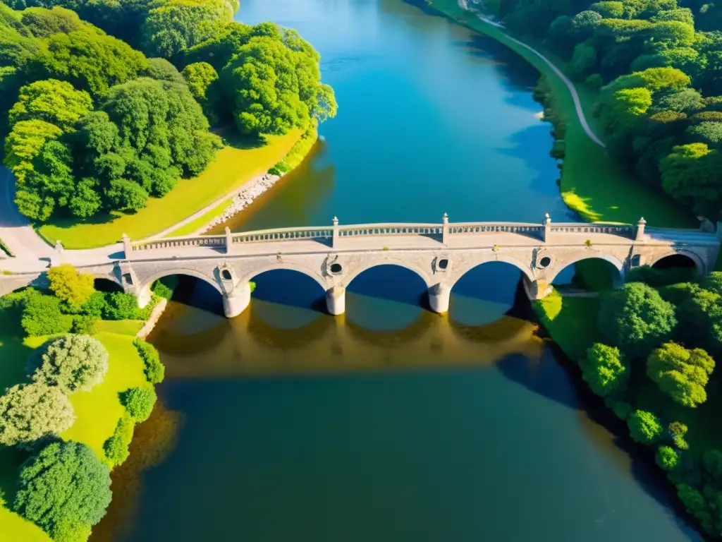 Contribución de drones a puentes: Impactante vista aérea de un majestuoso puente de piedra sobre un amplio río, bañado por la luz del sol