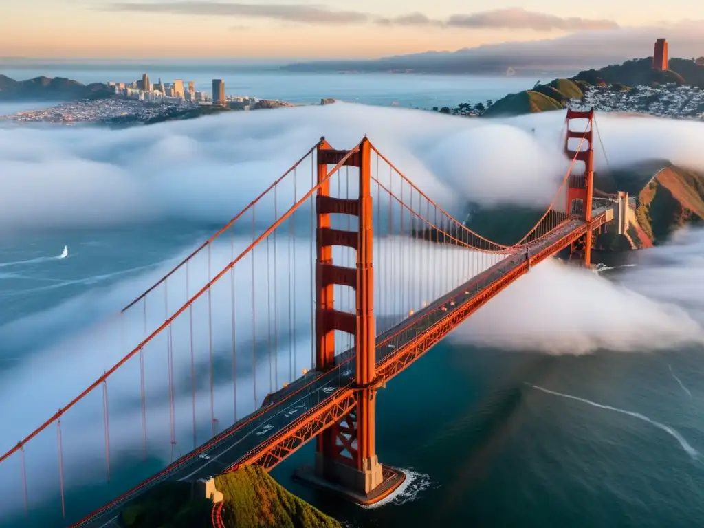 Vista aérea del icónico Puente Golden Gate envuelto en espeso neblina, con sus torres rojas asomando entre la niebla y cables de suspensión desapareciendo en las nubes